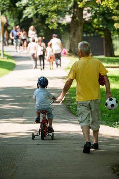 happy grandfather and child have fun and play in park on beautiful  sunny day