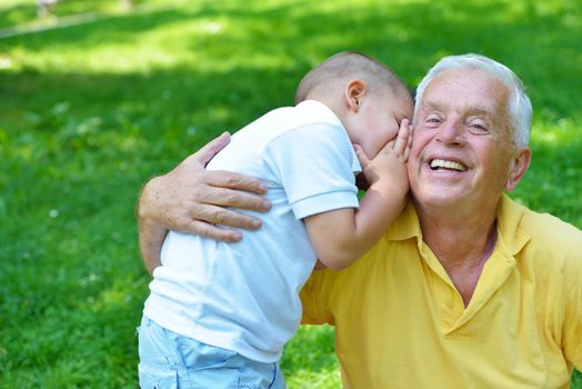 happy grandfather and child have fun and play in park