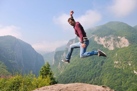 happy young man jump in nature while representing healthy lifestyle freedom and active concept