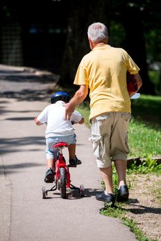 happy grandfather and child have fun and play in park on beautiful  sunny day