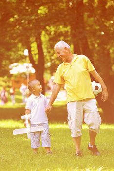 happy grandfather and child have fun and play in park