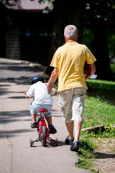 happy grandfather and child have fun and play in park on beautiful  sunny day