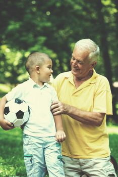 happy grandfather and child have fun and play in park on beautiful  sunny day