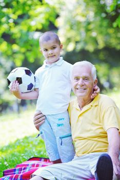 happy grandfather and child have fun and play in park