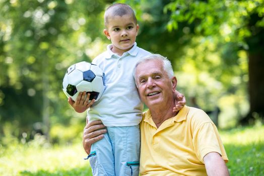 happy grandfather and child have fun and play in park on beautiful  sunny day