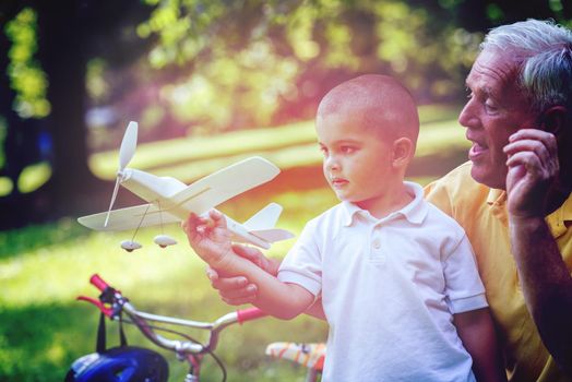 happy grandfather and child have fun and play in park on beautiful  sunny day