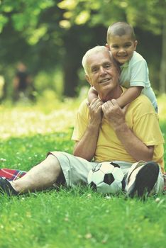 happy grandfather and child have fun and play in park