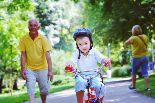 happy grandfather and child have fun and play in park