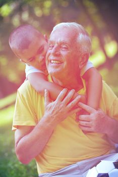 happy grandfather and child have fun and play in park