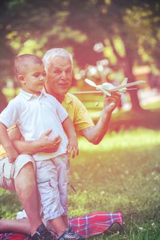 happy grandfather and child have fun and play in park on beautiful  sunny day