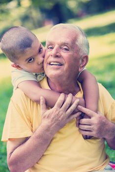 happy grandfather and child have fun and play in park on beautiful  sunny day