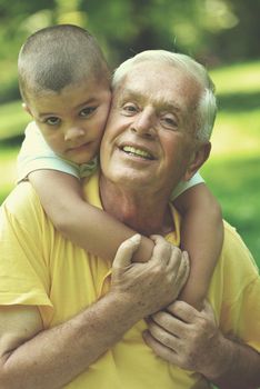 happy grandfather and child have fun and play in park