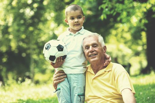 happy grandfather and child have fun and play in park on beautiful  sunny day