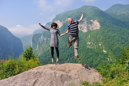 happy young couple in love jump in air in beautiful green and fresh nature