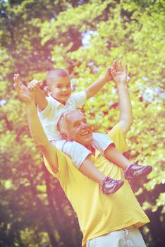 happy grandfather and child have fun and play in park