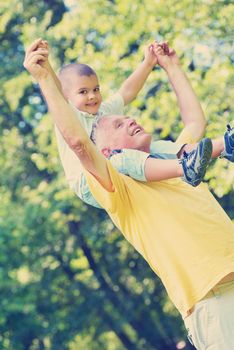 happy grandfather and child have fun and play in park