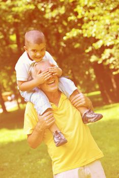 happy grandfather and child have fun and play in park