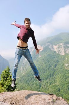 happy young man jump in nature while representing healthy lifestyle freedom and active concept