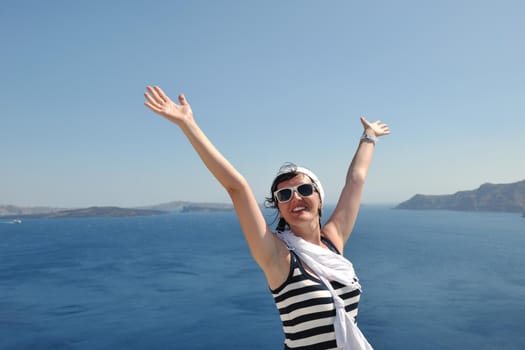 Beautiful young Greek woman in fashion clothes have fun at n the streets of Oia, Santorini, Greece