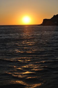 romantic sunset at sea eith tourist and travel boats on horizon