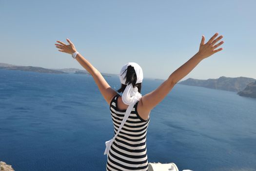 Beautiful young Greek woman in fashion clothes have fun at n the streets of Oia, Santorini, Greece