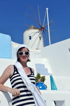 Beautiful young Greek woman in fashion clothes have fun at n the streets of Oia, Santorini, Greece