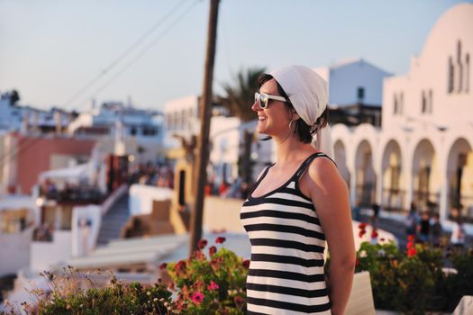 Beautiful young Greek woman in fashion clothes have fun at n the streets of Oia, Santorini, Greece