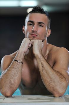 young healthy good looking macho man model athlete at hotel indoor pool