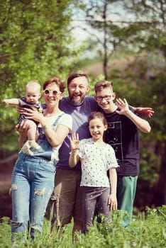 portrait of happy young big hipster family while  having picninc and fun time in nature