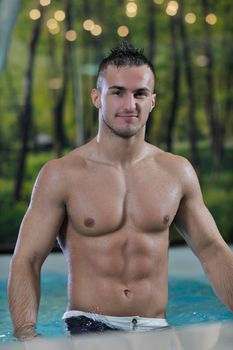 young healthy good looking macho man model athlete at hotel indoor pool