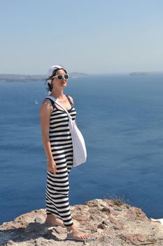 Beautiful young Greek woman in fashion clothes have fun at n the streets of Oia, Santorini, Greece