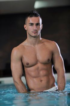 young healthy good looking macho man model athlete at hotel indoor pool