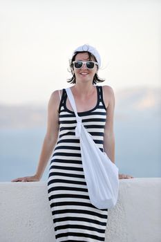 Beautiful young Greek woman in fashion clothes have fun at n the streets of Oia, Santorini, Greece