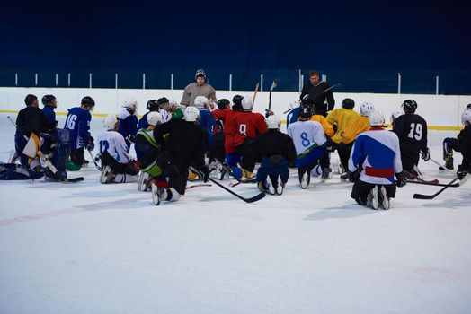 ice hockey players team group meeting with trainer  in sport arena indoors