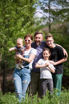 portrait of happy young big hipster family while  having picninc and fun time in nature