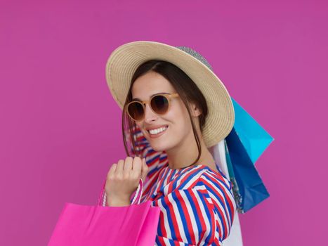 Young woman with shopping bags on pink background. Happy girl posing with new purchases after a day of big sale. Black Friday concept