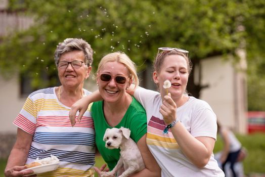 Portrait of grandmother with daughter and granddaughter in park while having fun