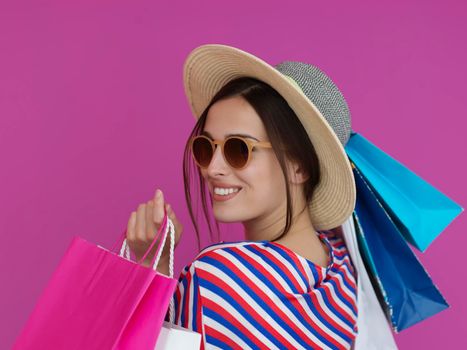 Young woman with shopping bags on pink background. Happy girl posing with new purchases after a day of big sale. Black Friday concept