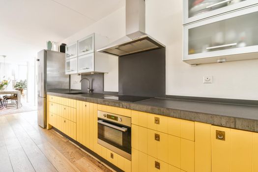Pretty kitchen with yellow kitchen unit and hanging cabinets with frosted glass