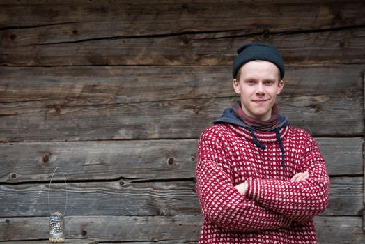 portrait of young hipster,  man with nose piercing  in front of old vintage wooden house