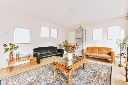 Lovely living room with black leather sofa and wooden coffee table