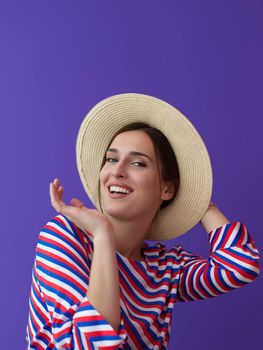 Portrait of young woman sitting on the chair isolated on purple background. Female model in casual and modern clothes posing in the studio