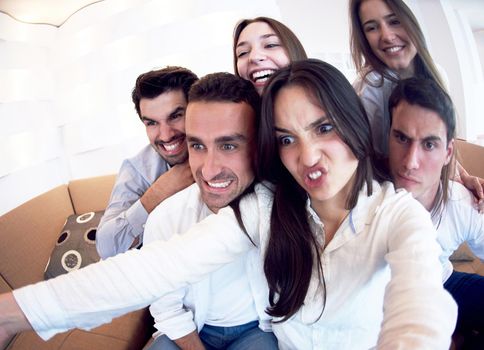 group of friends taking selfie photo with tablet at modern home indoors