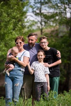 portrait of happy young big hipster family while  having picninc and fun time in nature