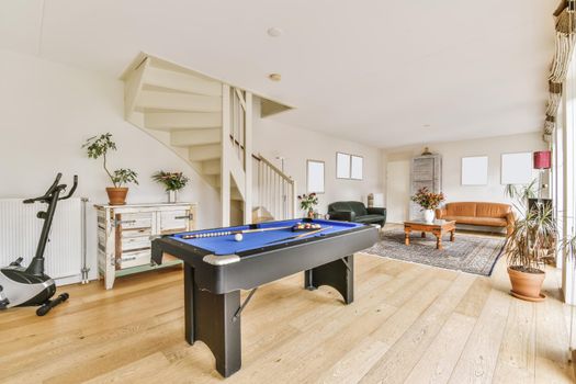 Lovely living room with black leather sofa and pool table