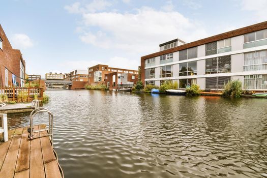 Adorable wooden boathouse in front of brick houses