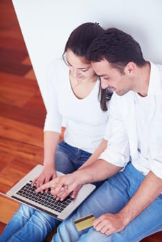 happy young relaxed  couple working on laptop computer at modern home interior