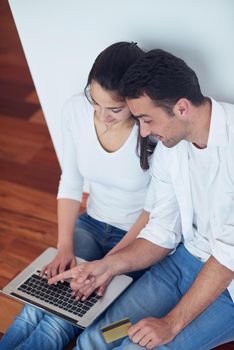 happy young relaxed  couple working on laptop computer at modern home interior