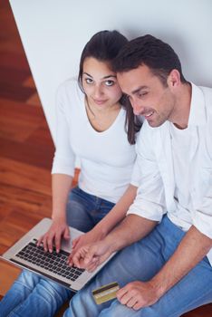 happy young relaxed  couple working on laptop computer at modern home interior