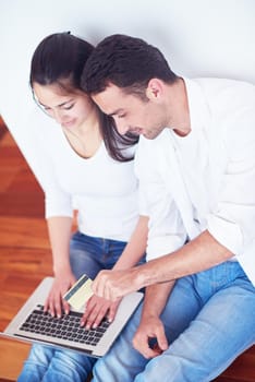 happy young relaxed  couple working on laptop computer at modern home interior